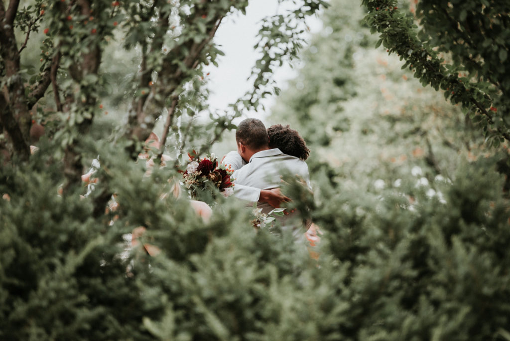 groom and brother hugging after at Green Bay botanical garden wedding