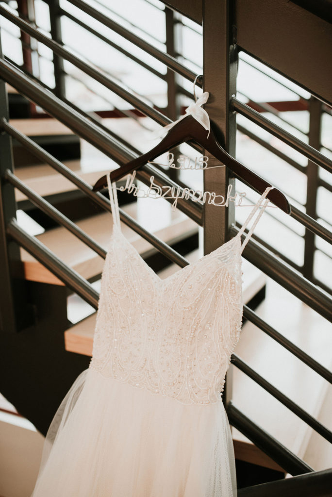 wedding dress with beaded top hanging at indira salon