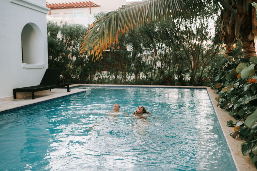 couple swimming in dip pool before destination wedding