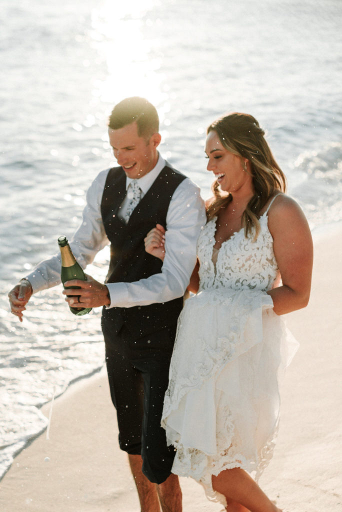 bride and groom popping champagne at destination Dominican beach wedding