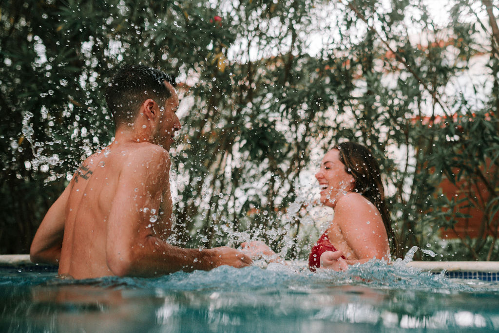 couple splashing in pool after destination elopement