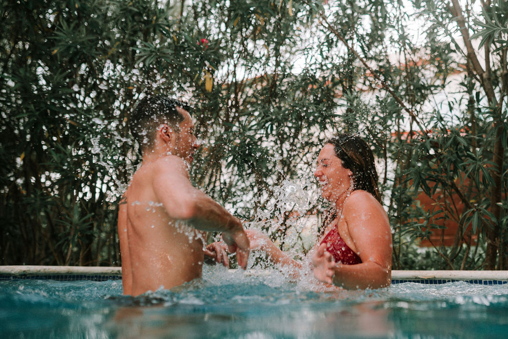 couple splashing in pool after destination elopement